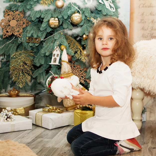 Retrato de niña linda entre adornos navideños