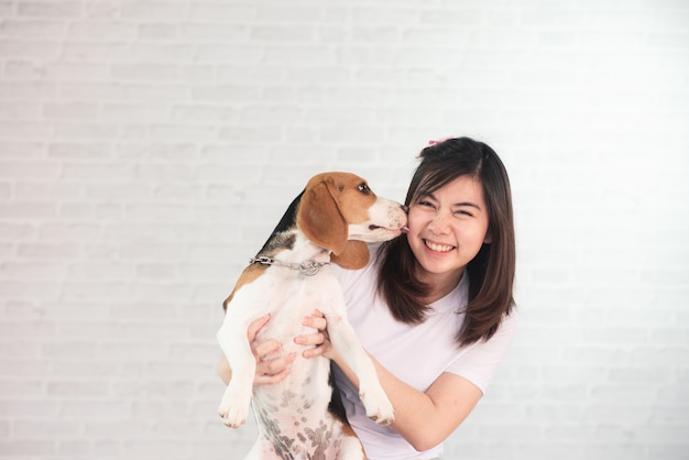 Retrato de niña linda y beagle cachorro sobre fondo blanco