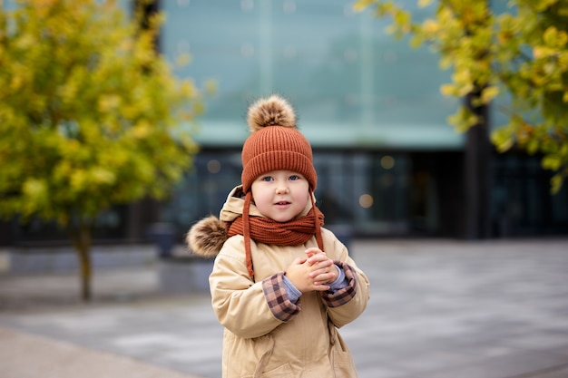 Retrato de niña linda caminando en el parque de la ciudad de otoño