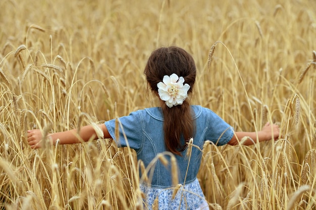 Retrato de niña linda en campo de trigo