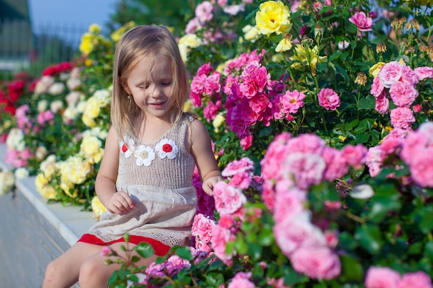 Retrato de niña linda cerca de las flores en el patio de su casa