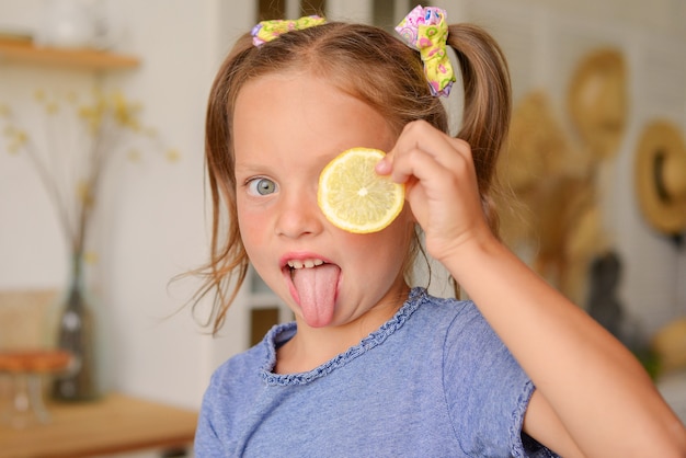 Retrato de una niña linda en la cocina con abarrotes y comida sana