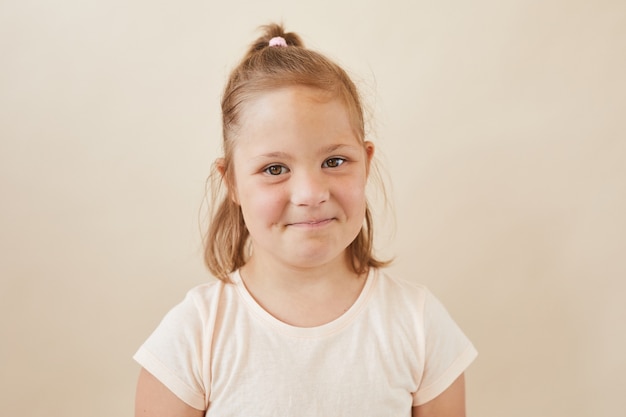 Retrato de niña linda contra el fondo blanco.