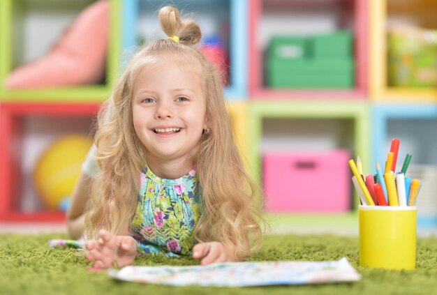 Retrato de niña linda dibujando en el piso