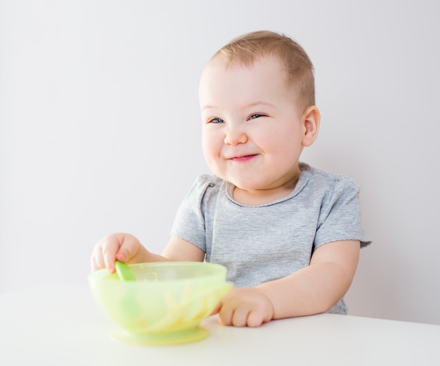 Retrato de niña linda divertida comiendo en la cocina