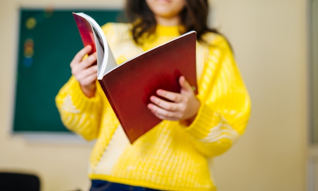 Retrato de niña linda leyendo el libro en el aula