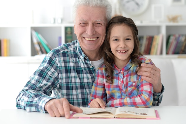 Retrato de niña linda con libro de lectura de abuelo