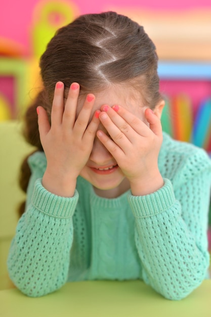 Foto retrato de niña linda que cubre la cara