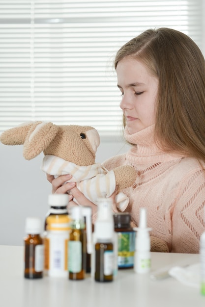 Retrato de una niña linda que toma la medicina en casa