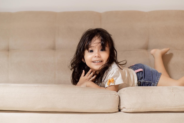 Retrato de niña linda sentada en el sofá