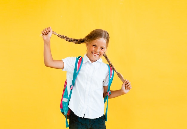 Retrato de una niña linda sobre un fondo amarillo.