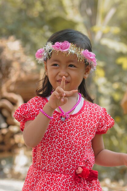 Foto retrato de una niña linda sonriendo mientras apunta con el dedo