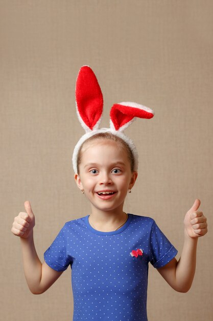 Retrato de una niña linda vestida con orejas de conejo de Pascua muestra gesto perfectamente