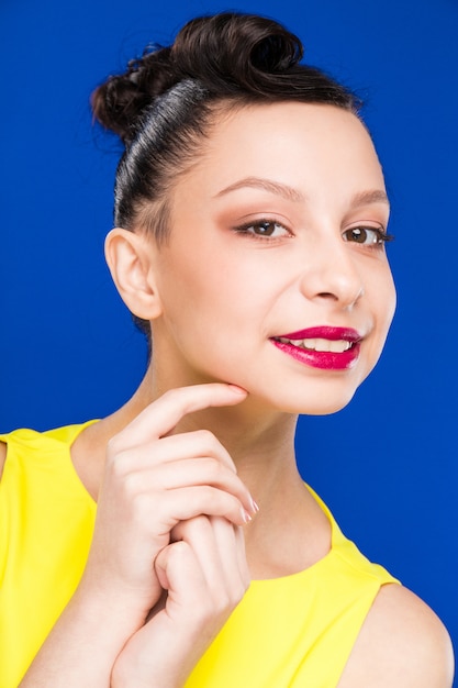 Retrato de niña con maquillaje en vestido amarillo