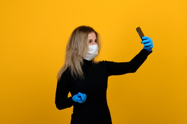 Retrato de una niña con una máscara médica sobre un fondo amarillo