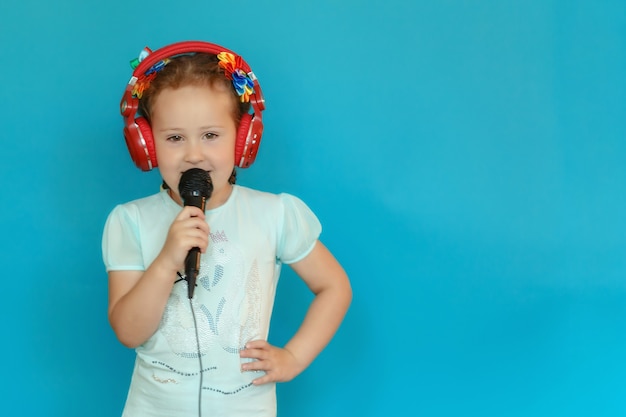 Foto retrato de una niña con un micrófono y auriculares