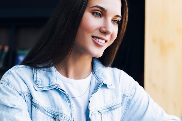 Foto retrato de niña milenaria en camisa vaquera en posición cómoda.