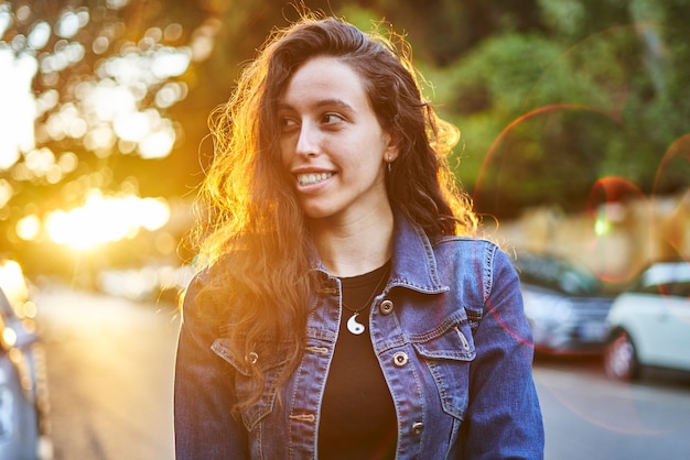 Retrato de niña morena en chaqueta vaquera al atardecer