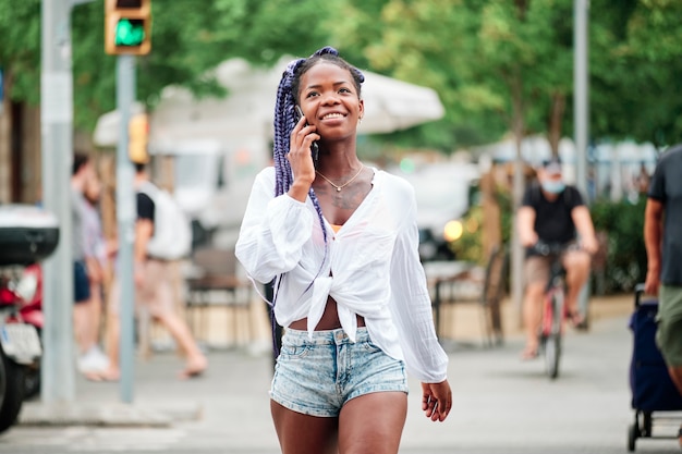 Retrato de una niña negra caminando en la ciudad