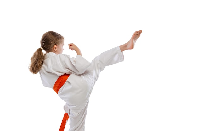 Retrato de niña, niño en kimono formación karate aislado en blanco. Vista trasera