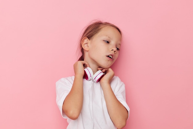 Retrato de niña niño sonriente feliz en una camiseta blanca con auriculares infancia inalterada