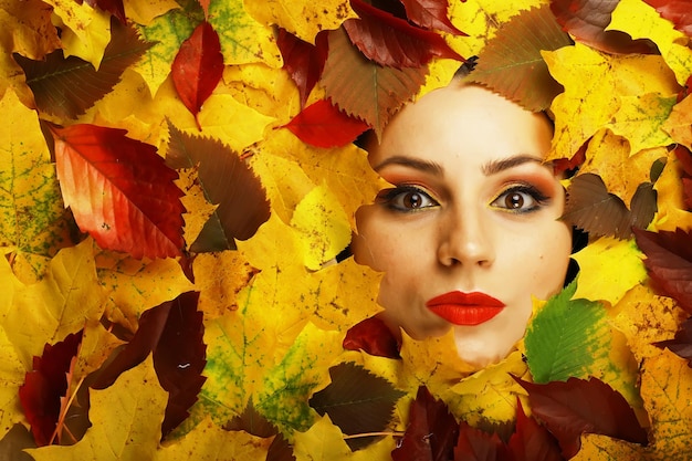 Retrato de niña de otoño conceptual artístico Hojas coloridas Hojas de árboles alrededor de una cara emocional Se acerca el otoño