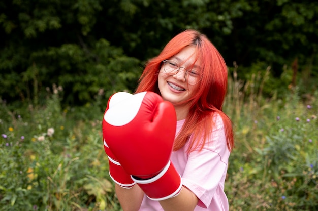 Retrato de niña pelirroja confiada con guantes de boxeo