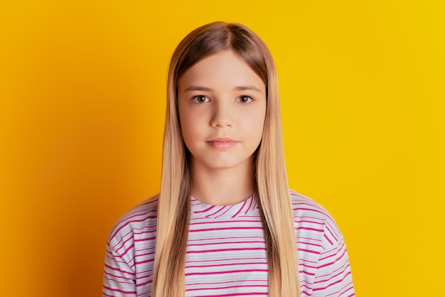 Retrato de niña de pelo rubio aislado sobre fondo amarillo