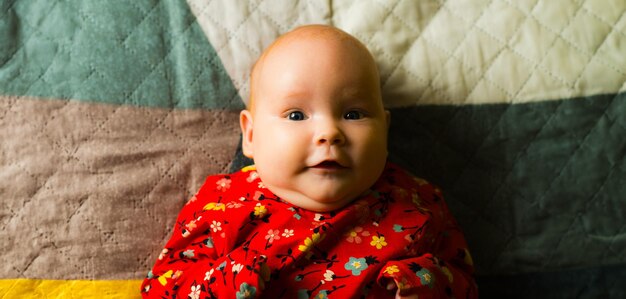 Retrato de una niña pequeña y linda acostada en la cama