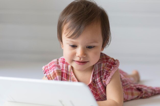 Retrato de una niña pequeña mirando una tableta digital