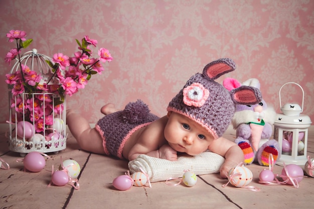 Retrato de niña pequeña con orejas de conejo en el fondo de la decoración de Pascua