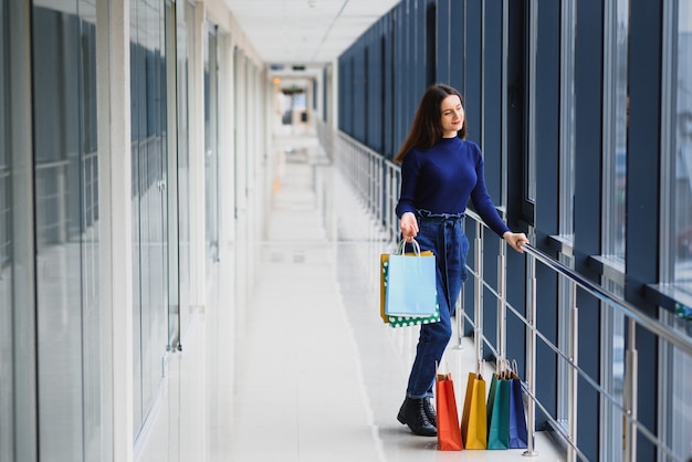 Retrato de niña de pie en el centro comercial después de hacer compras