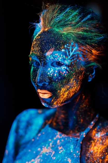 Retrato de una niña pintada en polvo fluorescente.