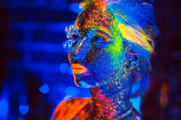 Retrato de una niña pintada en polvo fluorescente.