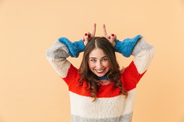 Retrato de niña positiva de 20 años sonriendo, estando aislado