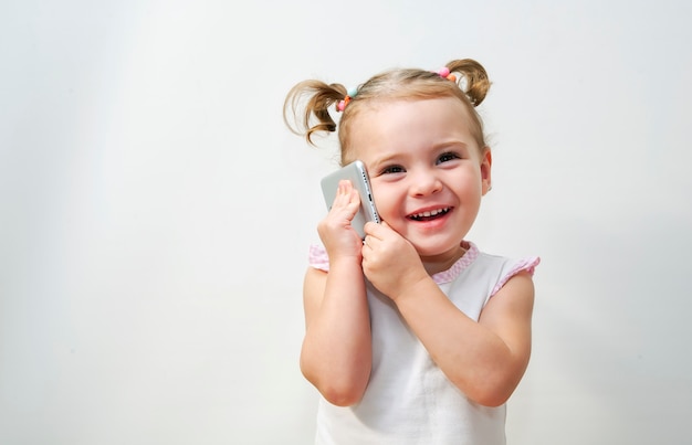 Retrato de la niña positiva de que hablar por teléfono.