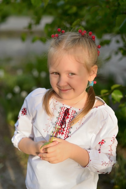 Retrato de una niña preescolar con una flor en una camisa bordada de Ucrania