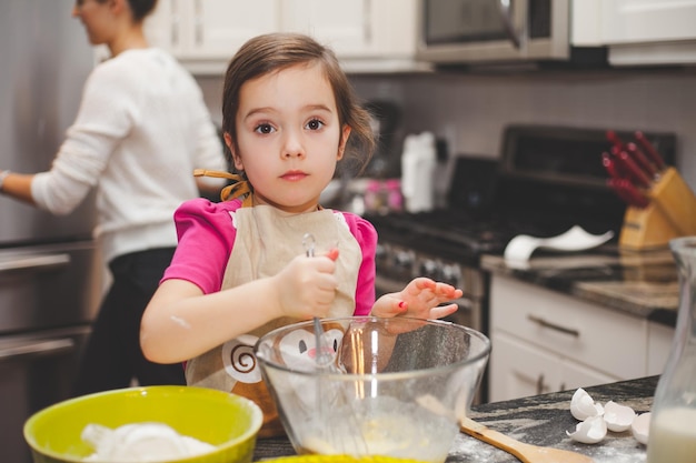 Retrato de una niña preparando comida en casa