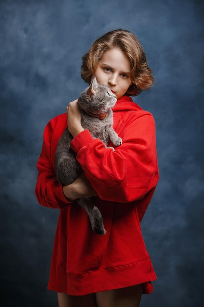 Retrato de una niña con un primer plano de gato sobre un fondo azul, un hombre y un animal