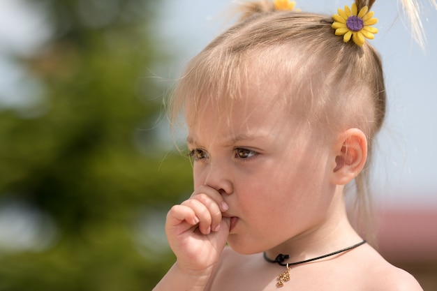 Retrato de una niña con un pulgar en la boca