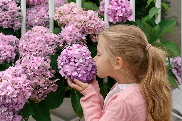 Retrato de una niña que huele hortensia