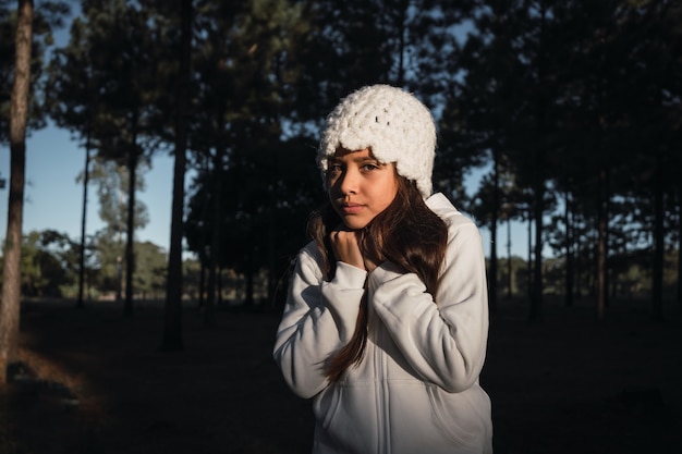 Retrato de una niña que siente frío con un gorro de lana al aire libre.