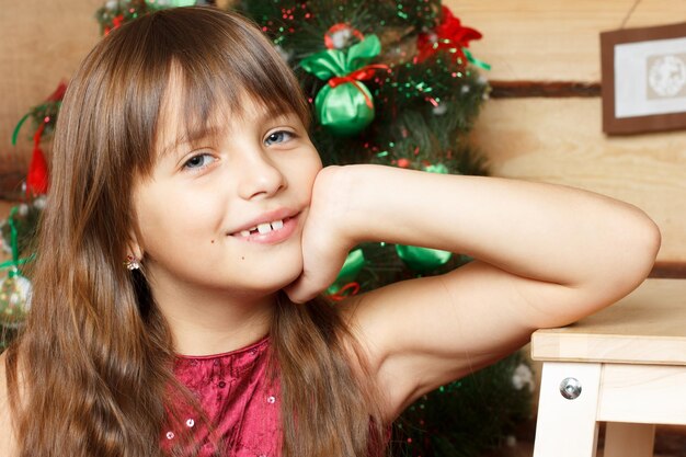 Retrato de la niña que sonríe niña con abeto