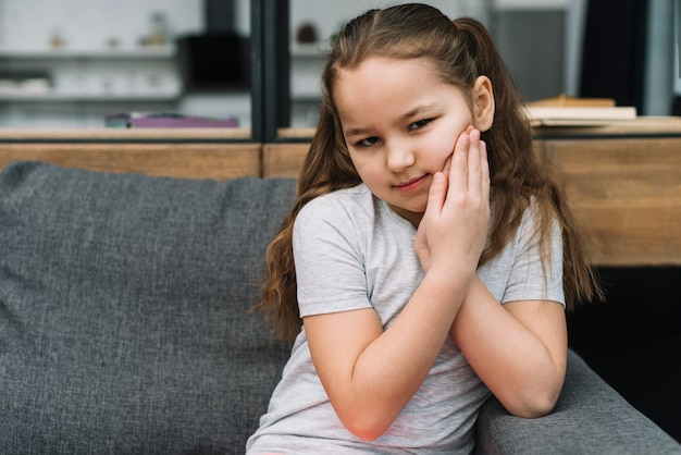 Foto retrato de una niña que sufre de dolor de muelas