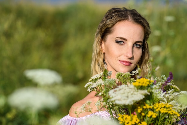 Retrato de una niña con un ramo de flores silvestres de cerca.