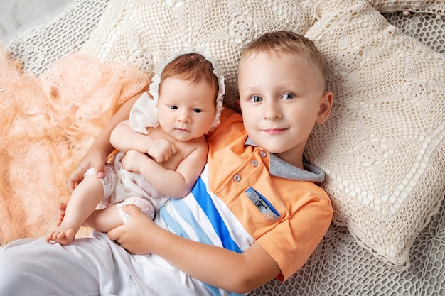 Retrato de niña recién nacida y hermano mayor. Niño joven, acostado, con, hermana recién nacida