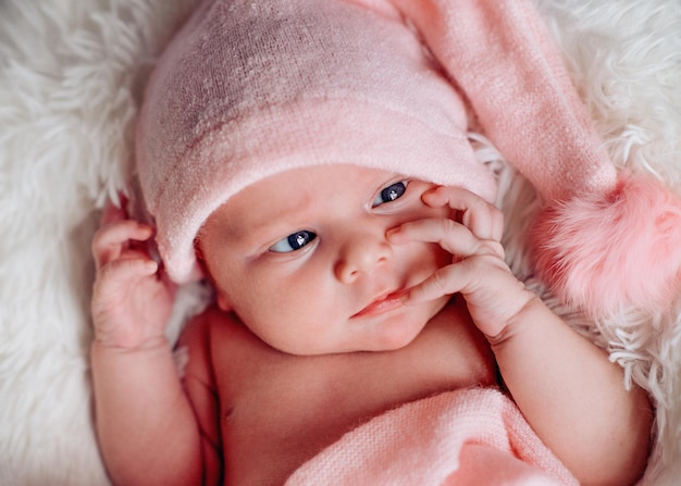 retrato de una niña recién nacida con un sombrero blanco