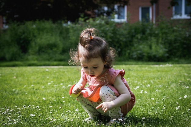 Retrato de una niña recogiendo margaritas en el parque