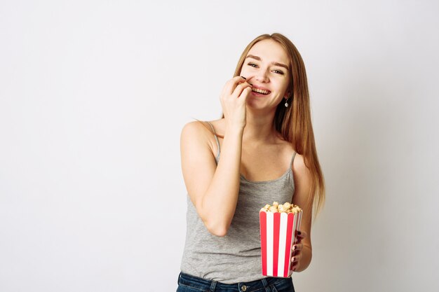 Retrato de una niña en ropa casual con caja de palomitas de maíz