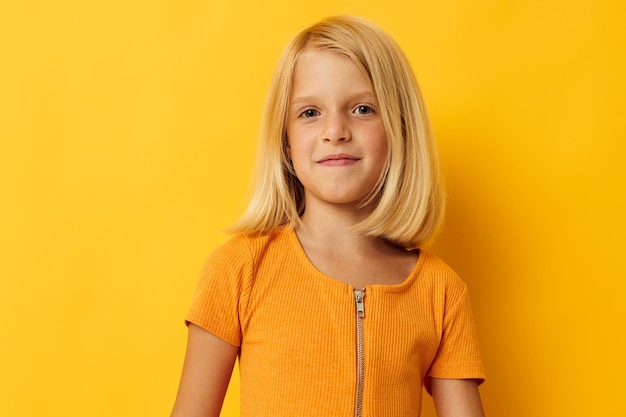 Retrato de una niña rubia pelo lacio posando sonrisa diversión fondo aislado inalterado